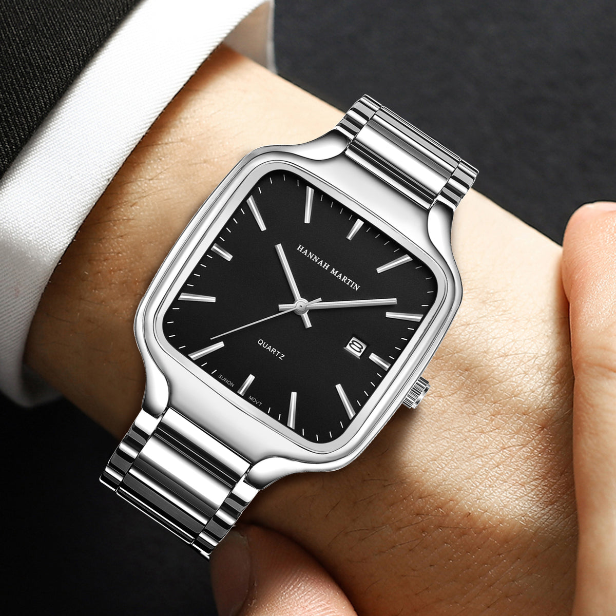 HM1691 silver-tone watch with black dial worn with a dark suit and white shirt