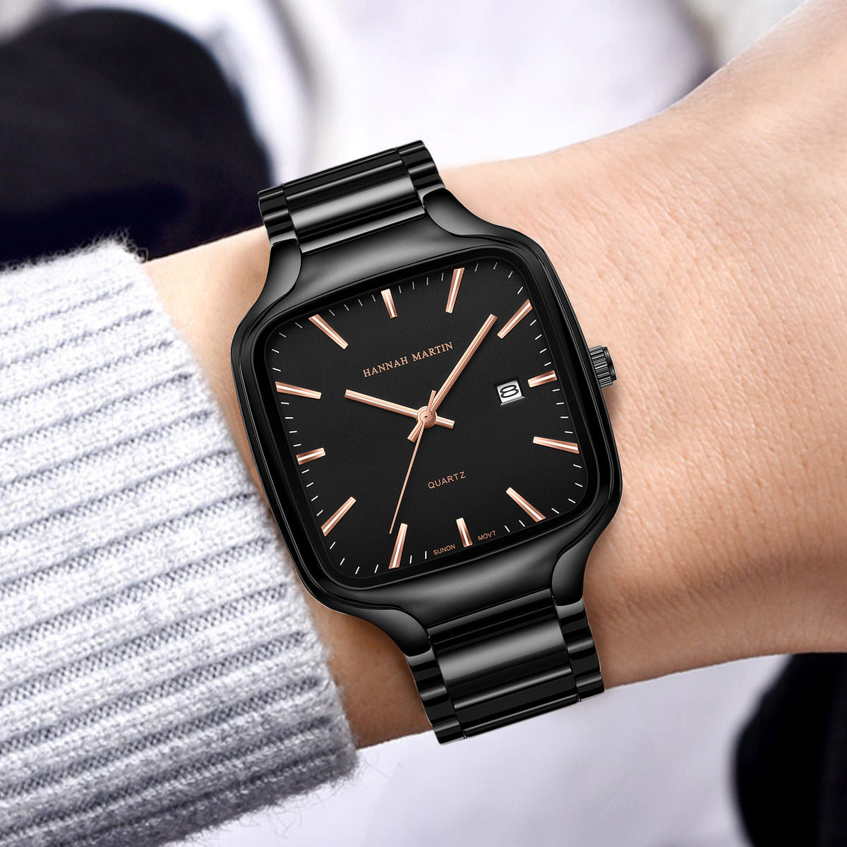 HM1691 black watch with rose-gold-tone hands worn with a gray knit sleeve