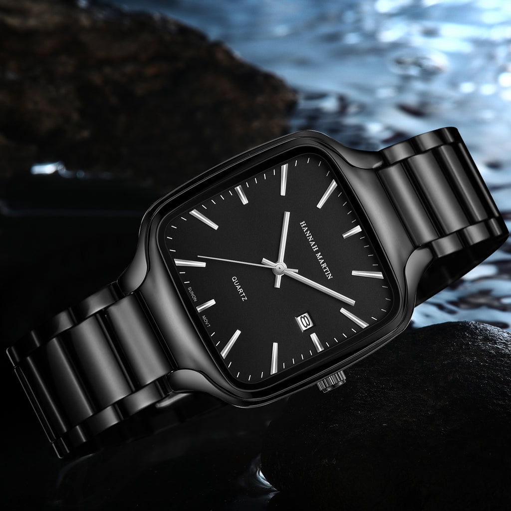 HM1691 black watch with silver-tone hands and markers resting on wet rocks beside water